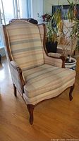 Front view of vintage wingback chair showing upholstery and wooden frame