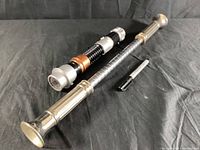 Photo showing vintage flashlight baton, toy lightsaber, and black marker pen on black fabric background, displaying overall condition and scale.