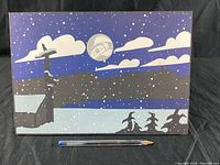Front view of the rectangular Indigenous artist print showing a snowy landscape with church, trees, moon, clouds, and snowflakes in dark blue and gray tones.