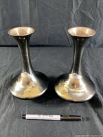 Pair of vintage Japanese metal vases with black finish and gold architectural scene near the base, shown with a marker for scale.