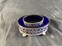 Smaller cobalt glass dish in sterling silver holder showing clear decorative silver cutout pattern and ball feet