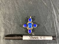 Top view of the cross pendant showing five deep blue lapis lazuli stones set in sterling silver with a Sharpie pen for scale.