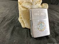Front side of the Zippo lighter showing Fred Smith engraving and Walker McDonald circular logo in color.