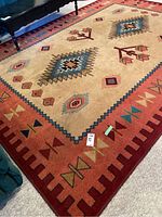 Full view of the rug showing native-style geometric pattern and red border.
