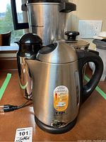 Photo showing T-fal Avante Pro electric kettle in stainless steel with black handle and base, water level indicator, front view.