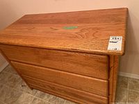 Front and top view of the oak dresser showing three drawers and natural wood grain.