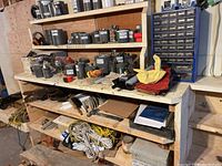 Wide shot of wooden shelving filled with containers of various hardware items including ropes, bolts, and bracket pieces.
