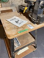 Top view showing lathe mounted on table with instruction manual and measurement sticker