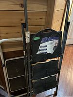 Photo showing folded Cosco step ladder with three black stepping platforms.