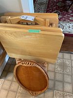 Photo of the front view of four wooden TV trays with holder and wooden oval tea tray.
