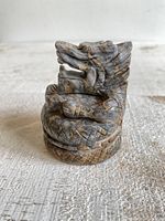 Front angled view showing dragon coiled on base with detailed carving and natural fossil bamboo stone coloration.