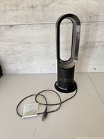 Three-quarter view showing oval loop, cylindrical base and attached power cord