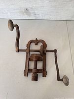 Top-down image of large vintage barn beam drill head showing handle and cog mechanism