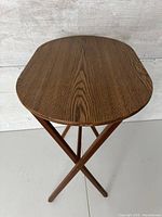Top view of vintage wooden folding side table with visible wood grain and rounded corners.