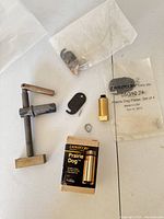 Overview of all components including clamps, plates, key, and packaging, showing minor wear and some unused in plastic bags.