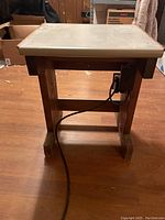 View of the front side showing the power outlet and power cable attached to the wooden end table.