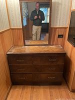 Full front view of the dresser with mirror showing six drawers and decorative metal handles.