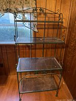 Full view of the three-tier metal shelving unit showing all shelves and curved side details.