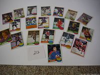 Overview image of 24 assorted vintage 1980 OPC hockey cards laid out in several rows on carpeted floor.
