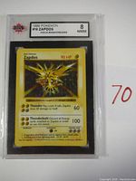 Front of encapsulated graded card showing label and holographic Zapdos