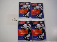 Four unopened 2007-2008 Upper Deck Victory hockey card packs in a group with a paper showing number 172.