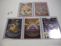 Five foil Pokémon cards including Kangaskhan (#115), Nidoqueen (#31), Grimer (#88), Magnemite (#81), and Primeape (#57). Cards are sleeved and holographic with reflective backgrounds.