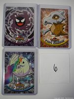 Front view of three Pokemon cards featuring Gastly, Cubone, and Dewgong in protective sleeves.