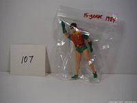 Robin action figure sealed in plastic bag marked 'Hi-grade 1984' with a number 107 card beside it.