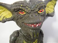 Close-up of the face of the Stripe Gremlins figure showing detailed sculpting and paint including red eyes, yellow inside large ears, and sharp teeth.