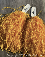 Pair of blue and gold Cal Golden Bears cheer pom poms with white handles branded with 'Cal'.