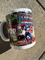 Side view of the ceramic mug showing comic cover art with Captain America, Thor, Marvel Comics logo and Hulk images.