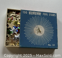 Box of vintage Eureka foil star stickers showing partially open lid with assorted colored star stickers inside.