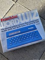 Box showing Franklin Word Wiz branding, image of blue spelling corrector device with QWERTY keyboard and LCD display.