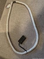 Full view of the Honora freshwater pearl necklace laid out on a flat surface showing the pearls and tag.