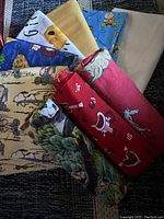 Fabric pieces displayed fanned out, showing various prints and colors including horse, koala, and Snoopy themes.
