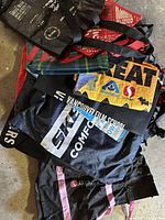 Pile of 9 reusable bags from multiple brands with various colors and designs.