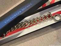 Gold-tone chain bracelet in Victoria's Secret black box with red interior, clasp visible.