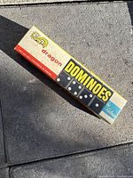 Original closed Dolpham branded rectangular domino box with yellow and red vintage design