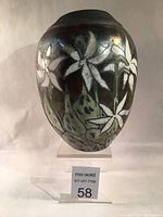 Front view showing white lily motifs and iridescent glaze