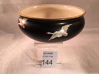 Front view of the vintage Grimwades bowl with matte black background and handpainted swans in flight, showing gilded rim and cream-colored interior.