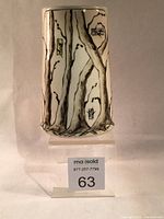 Front view of the rectangular ceramic vase with the tree design showing details of the branches and small colored blocks on glossy surface.