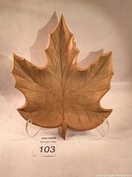 Front view of the carved maple leaf shaped side bowl, showing etched veins and light wood color.