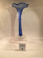 Front view of tall blue twisted soliflore vase on clear base