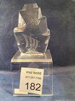 Front view of clear glass Viking ship paperweight showing smooth front etched with Viking ship design and textured 'iceberg' shape top.