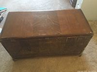 Top view of cedar chest showing finished wood surface with scratches and wear.