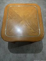 Top view of oak coffee table showing patterned inlay and gold-colored trim