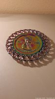 Full view of the multicolor iridescent carnival glass plate with Abraham Lincoln bust and laced edge.