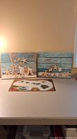 Front view of two sea-themed canvas prints and one placemat depicting Hawaiian Islands, all items arranged on a table against a plain wall.