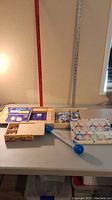 Lot contents showing 2 puzzles, light-up baton, and magnetic countdown toy on table