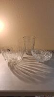 Photo showing all three glass items together: round punch bowl, tall vase with diamond pattern, and oval bowl with legs and pattern.